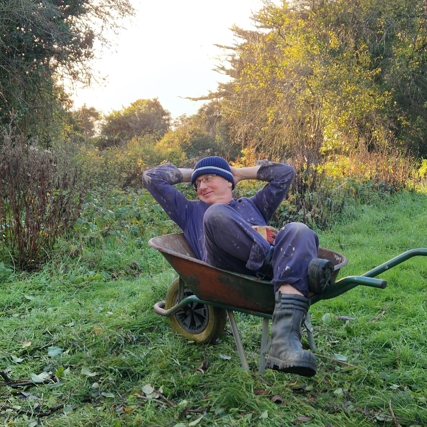 Man in wellies relaxing in a wheelbarrow
