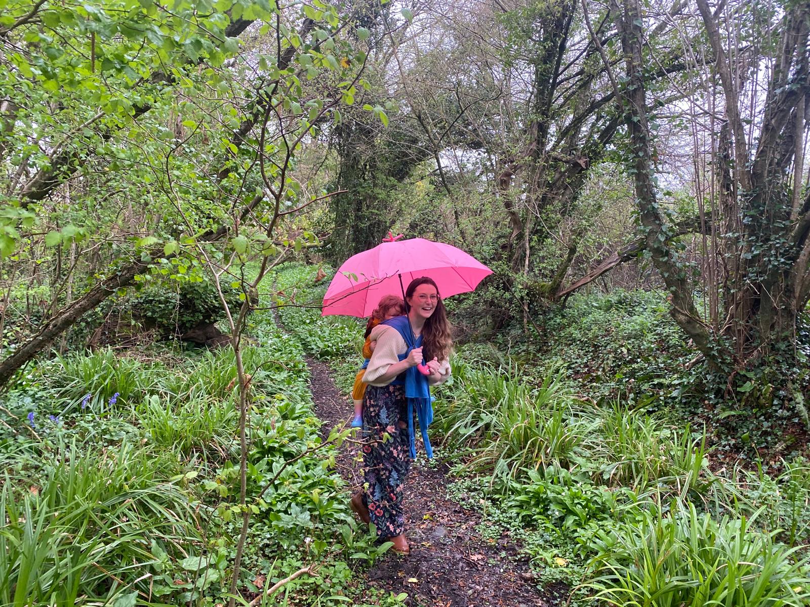 Mother and child with pink parasol in the Othona woodland