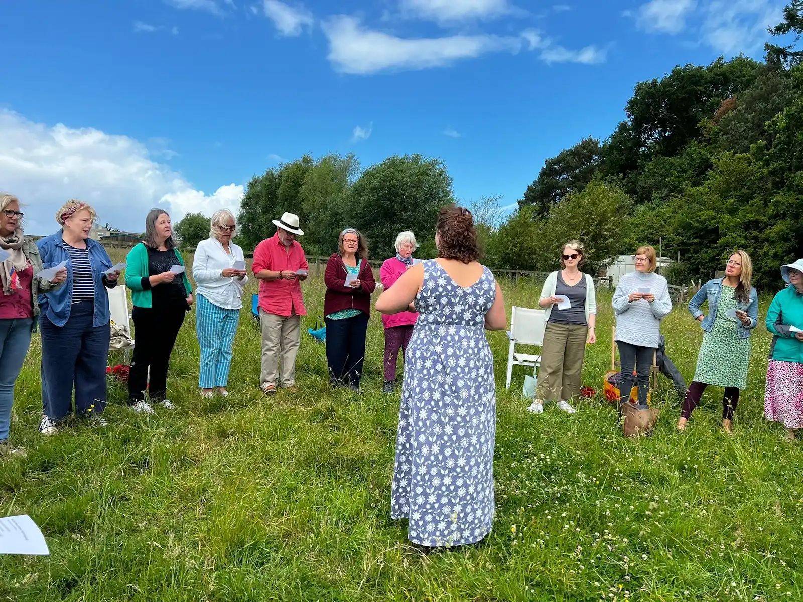 Suus Gooch teaching songs in the open air on a summer day